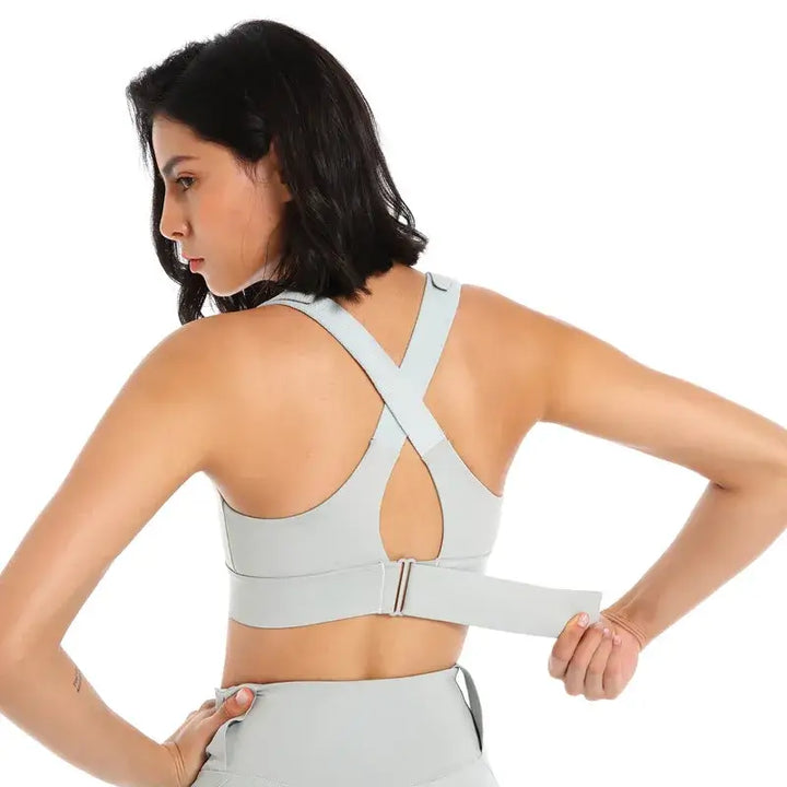 Woman showcasing the back of a light blue Front Zipper Sports Bra, highlighting its supportive design and adjustable straps.