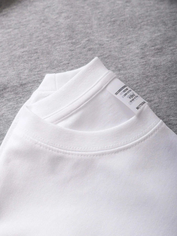 Close-up of white oversized unisex cotton t-shirt from the collection featuring a classic collar and label detail.